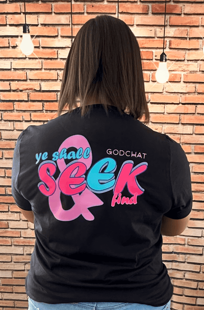 FEMALE WEARING BLACK SEEK AND YE SHALL FIND TEE WITH PINK AND BLUE DESIGN! BACK OF SHIRT.