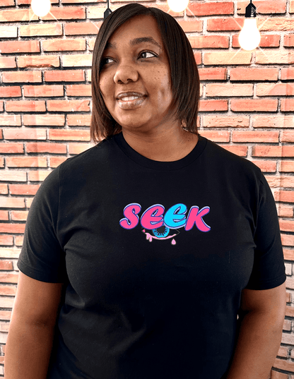 FEMALE WEARING BLACK SEEK AND YE SHALL FIND TEE WITH PINK AND BLUE DESIGN!
